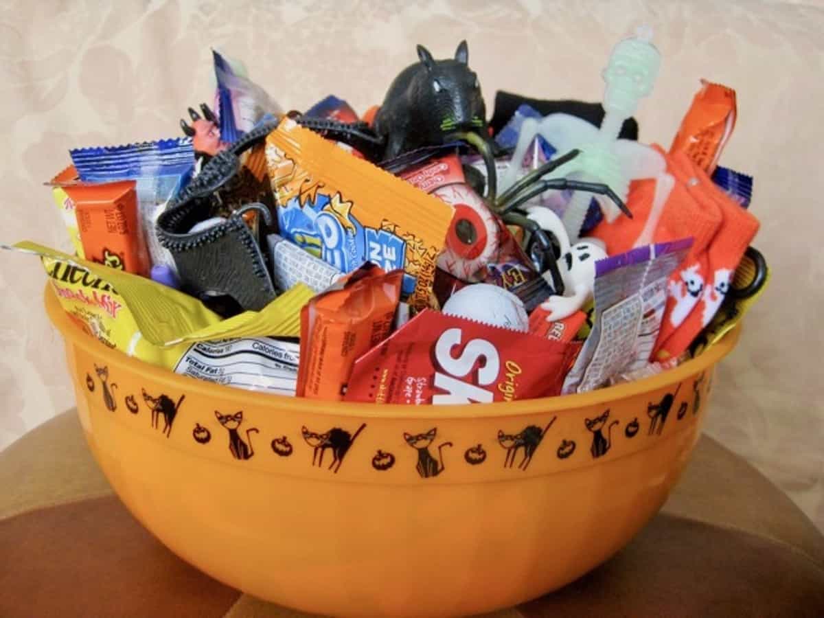 A "Spoiling Bag" of candy, seasonal socks and Halloween favors arranged in a Halloween themed bowl.