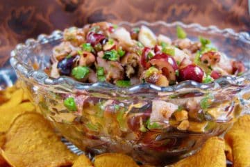 Cranberry Salsa in a glass serving dish surrounded by Baked Sweet Potato Chips