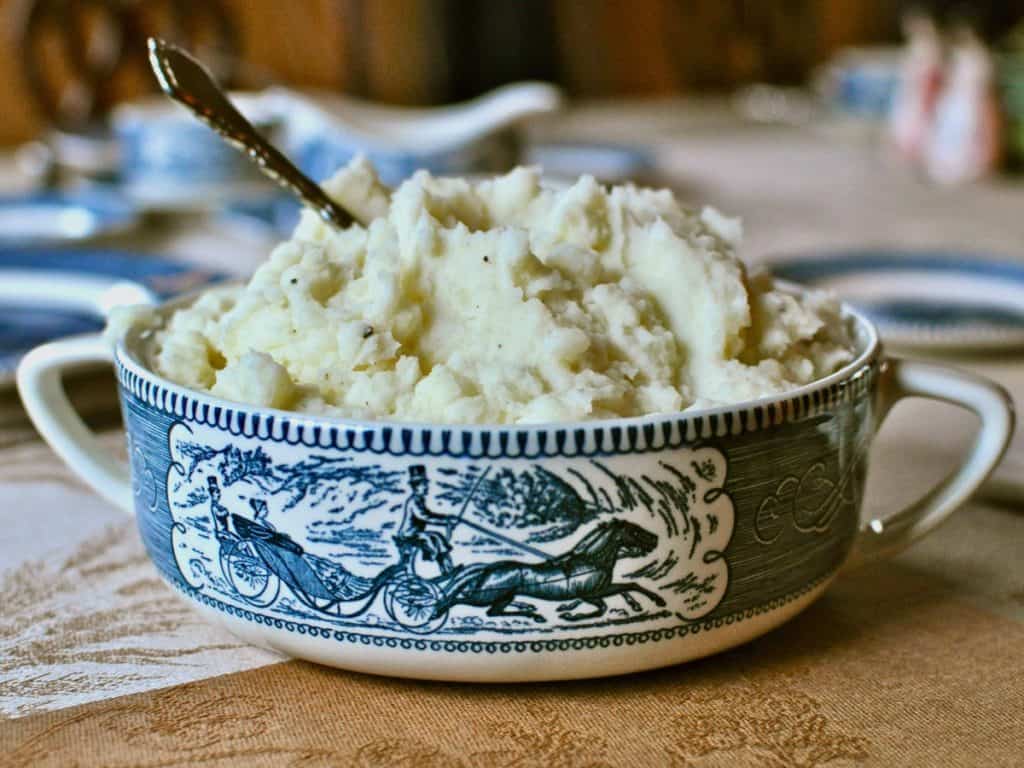 Mashed Potatoes piled in a Courier and Ives Ironstone dish with handles.