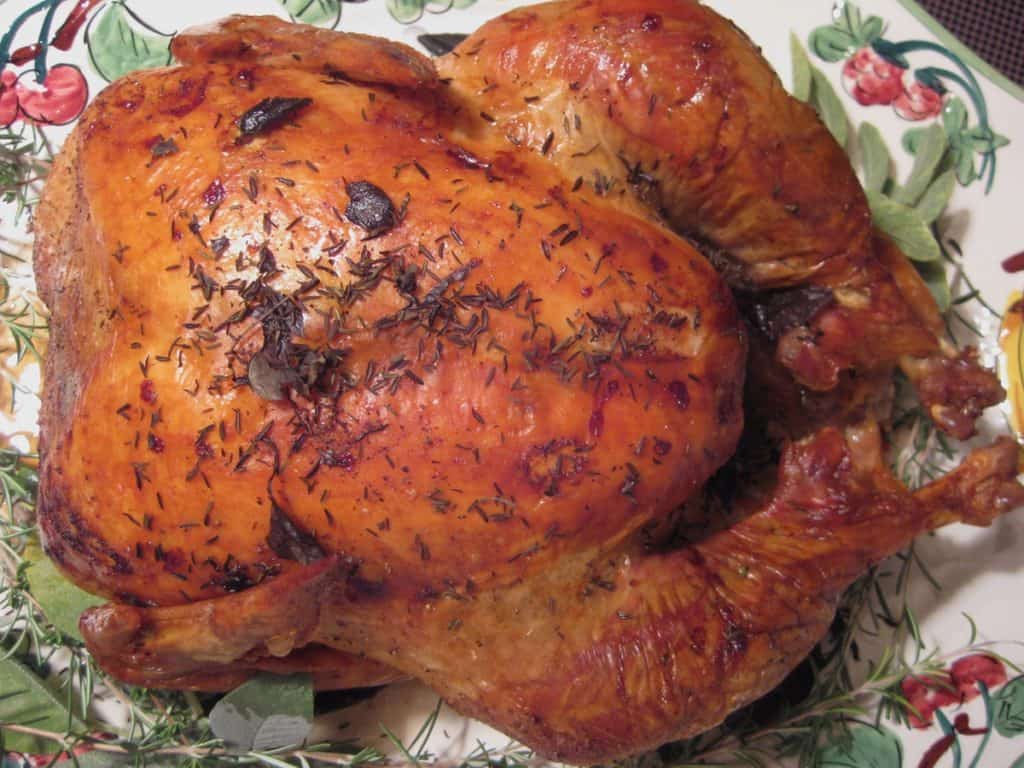 The Perfect Thanksgiving Turkey with crispy brown skin, strewn with herbs and served on a hand painted turkey platter.