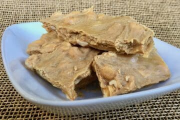 Pieces of Scrumptious Soft Peanut Brittle in a white dish.