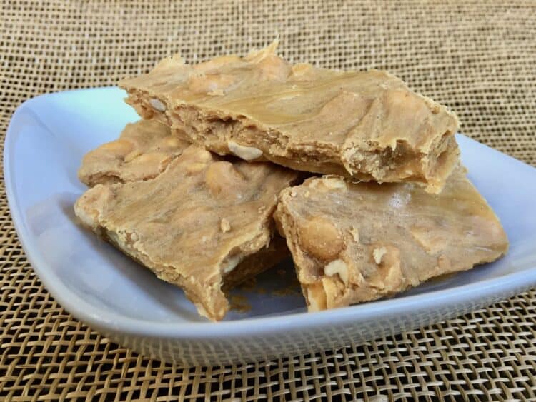 Pieces of Scrumptious Soft Peanut Brittle in a white dish.