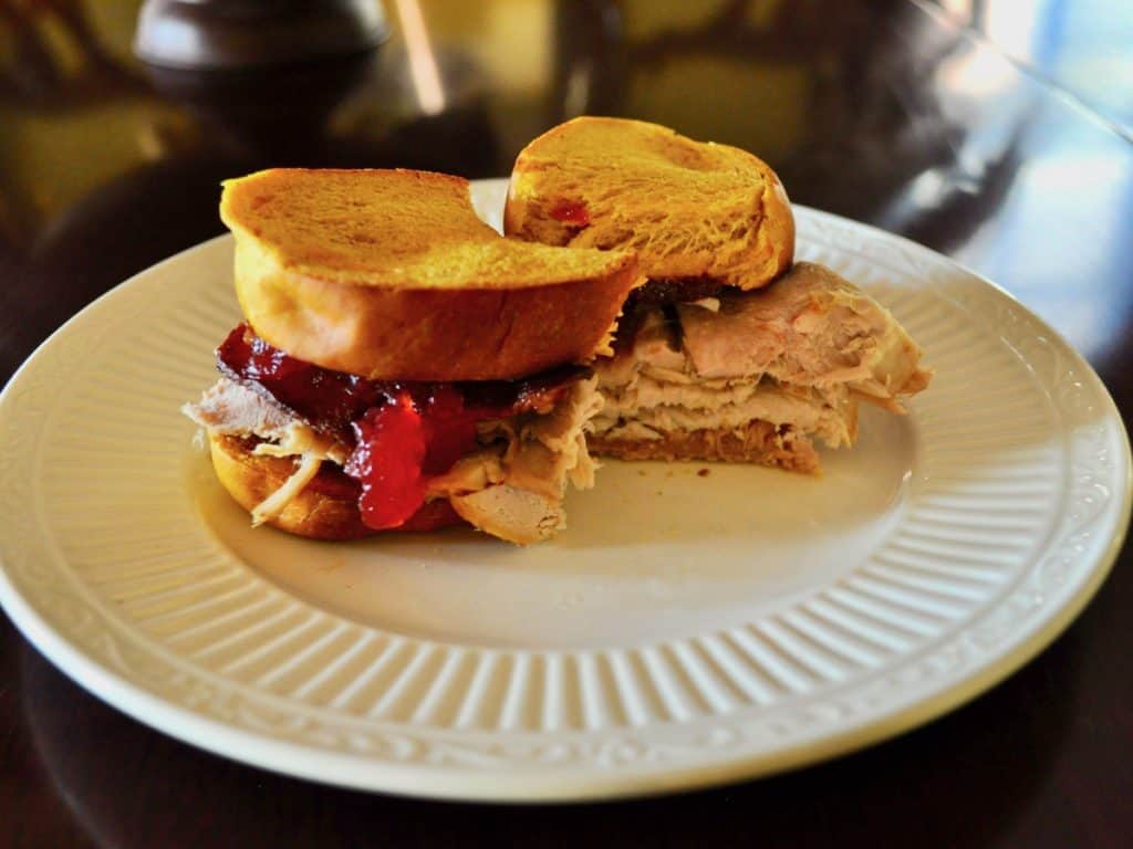The Best Turkey Sandwich sliced on top of a white plate.