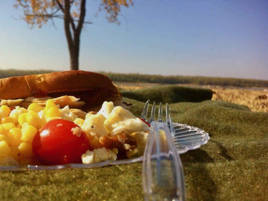 Corn Salad with Pecan Dressing served beside The Best Turkey Sandwich on a plate for a picnic at Mud Island.