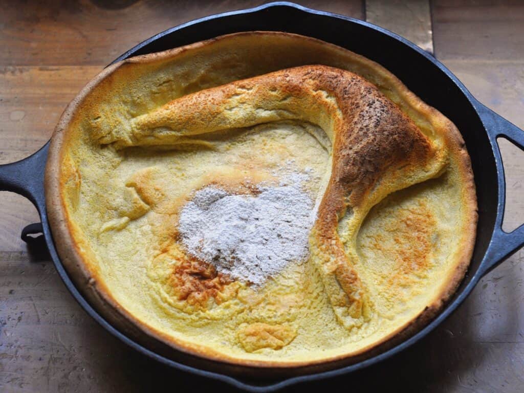 Snickerdoodle Pancake in Cast Iron Skillet with a powdered sugar heart dusted on top.