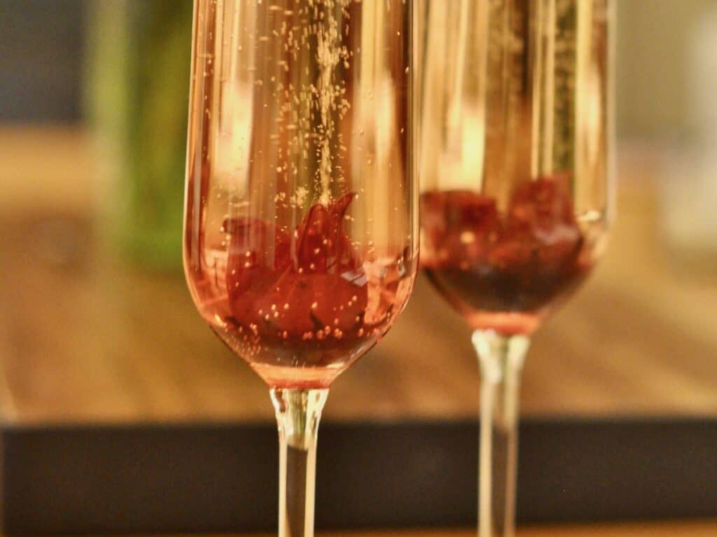 Champagne over Wild Hibiscus Flowers in Syrup makes a delicious champagne cocktail that is uniquely memorable.