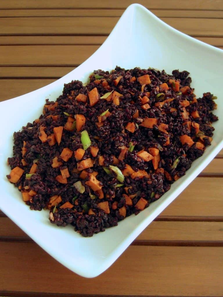 Black Rice with Gingered Sweet Potatoes served in an asymmetrical white bowl.