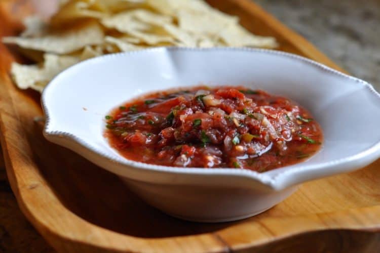 Cast-Iron Salsa in a white bowl with tortilla chips on a wooden tray