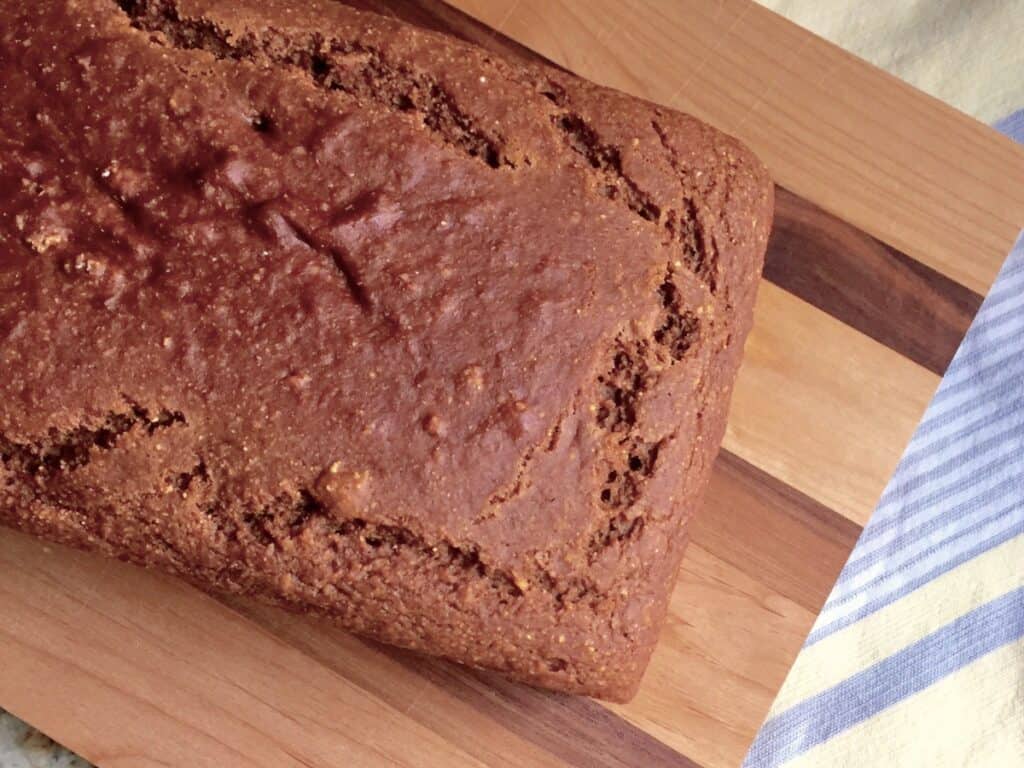 A loaf of Quick Whole Wheat Molasses Bread on a wooden cutting board.