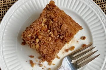 Sour Cream Coffee Cake with Cinnamon Streusel Topping on white plate with fork.