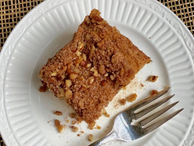 Sour Cream Coffee Cake with Cinnamon Streusel Topping on white plate with fork.