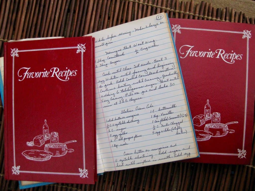 Several Cookbooks with handwritten recipes, one opened to the recipe for Meringue that Won't Weep