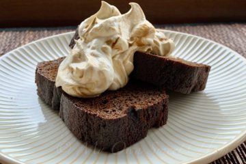 Slices of Gingerbread Loaf on a plate topped with Molasses Whipped Cream