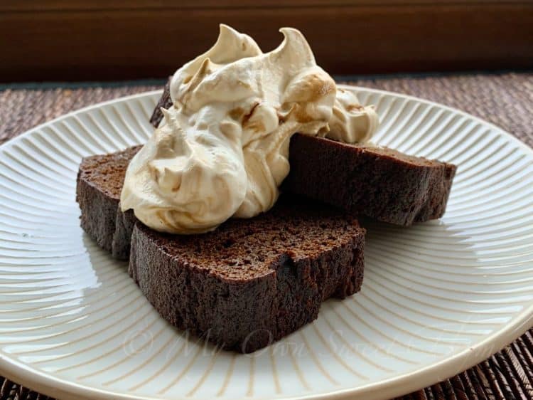 Slices of Gingerbread Loaf on a plate topped with Molasses Whipped Cream