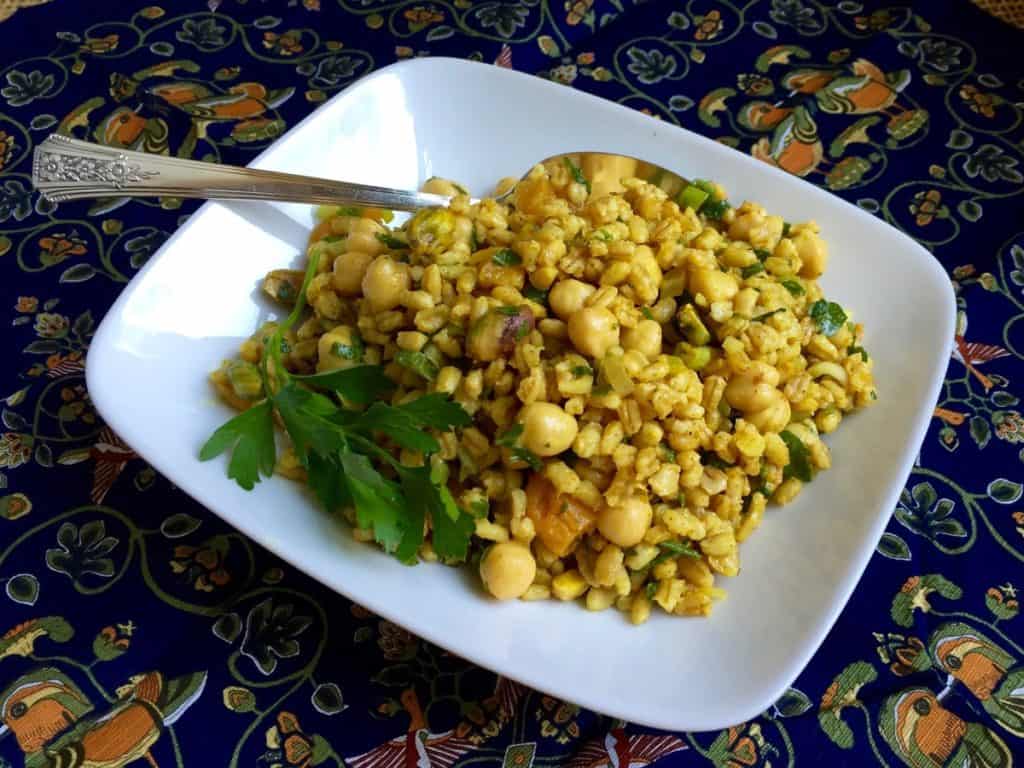 Moroccan Chickpea and Barley Salad on a a square plate with antique silver serving spoon.