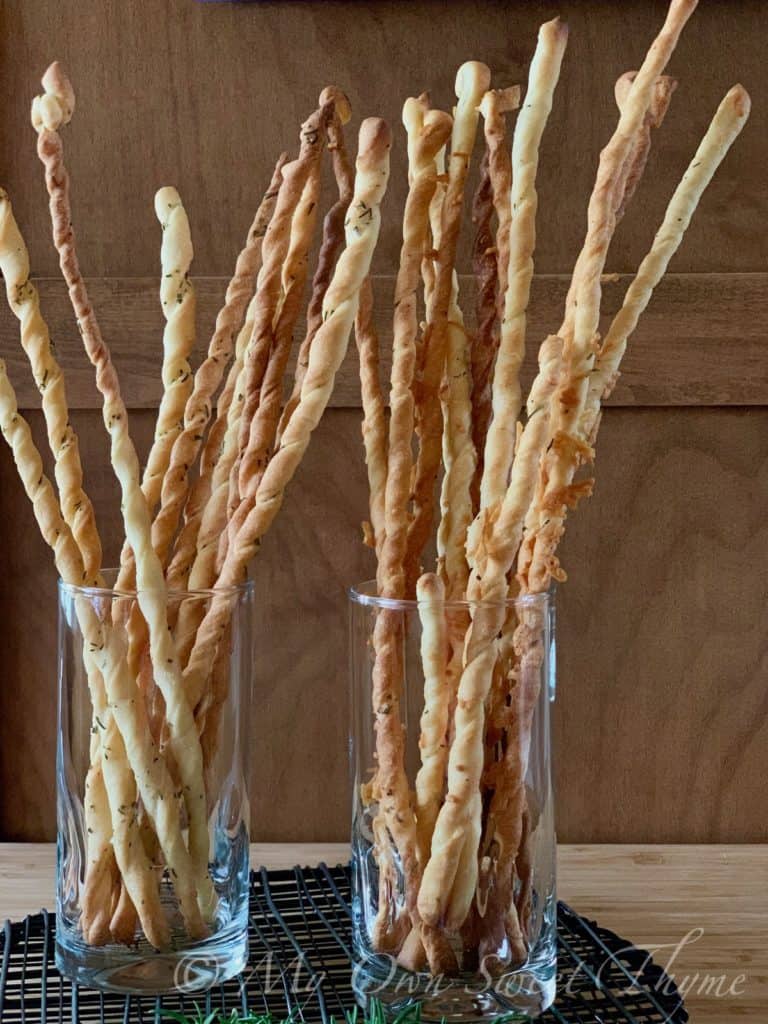Parmesan and rosemary grissini in tall glasses.