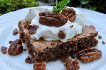 Mint Julep Brownie topped with whipped cream and whole pecans and garnished with a mint leaf