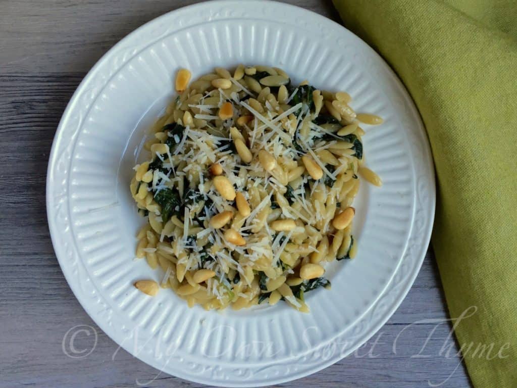 Orzo with Spinach and Pine Nuts garnish with shredded parmesan