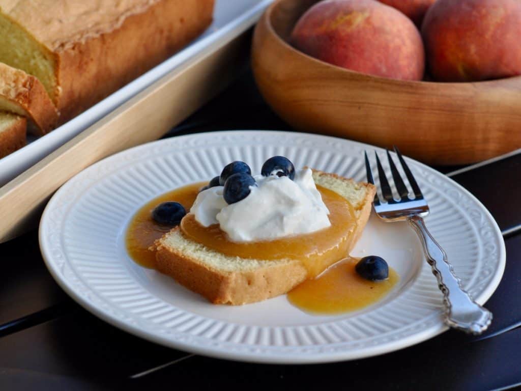 Cold Peach Soup spooned over Old Fashioned Pound Cake and garnished with Whipped Cream and blueberries