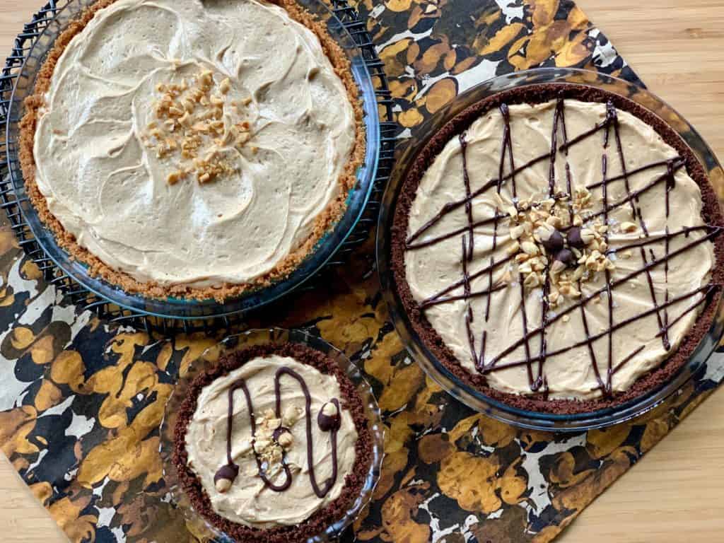 Three different Peanut Butter Pies arranged on a black and yellow napkin.