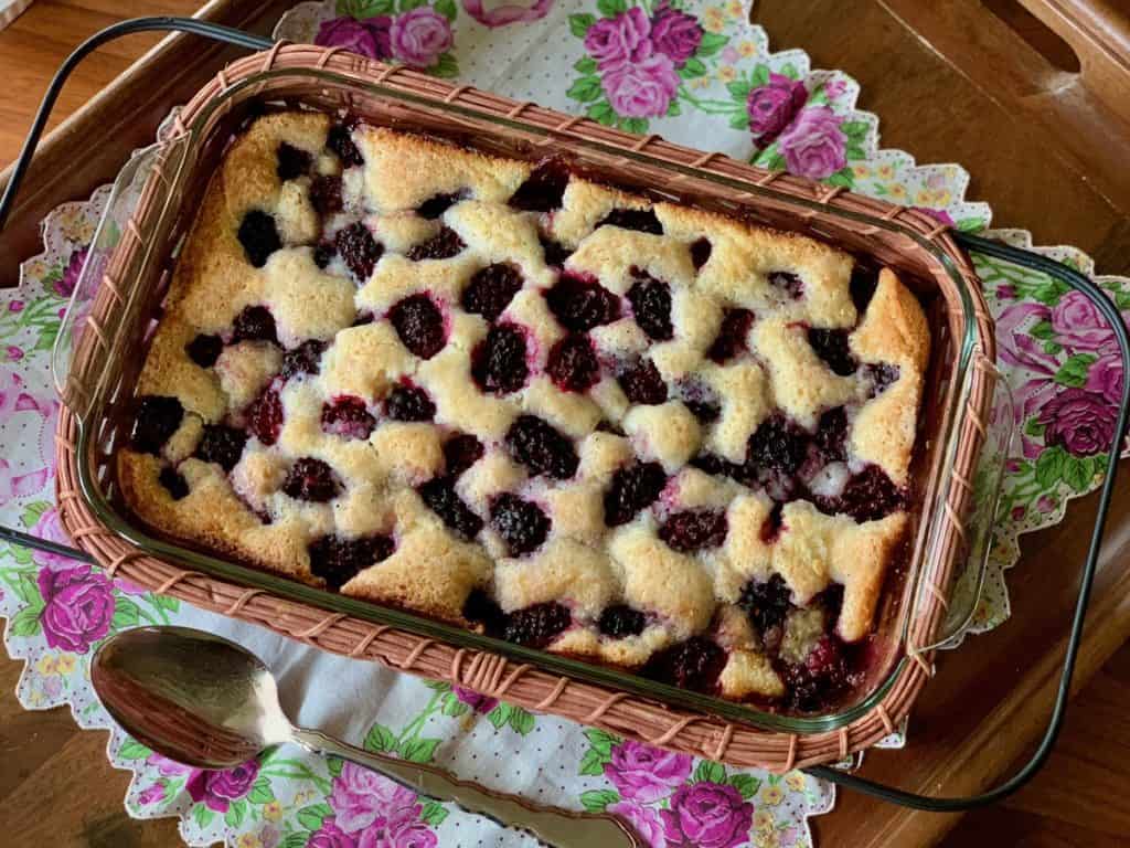 Mama Jean's Great Cobbler baked with Blackberries in a 9"x13" glass pan and served in a basket set on a vintage floral handkerchief.