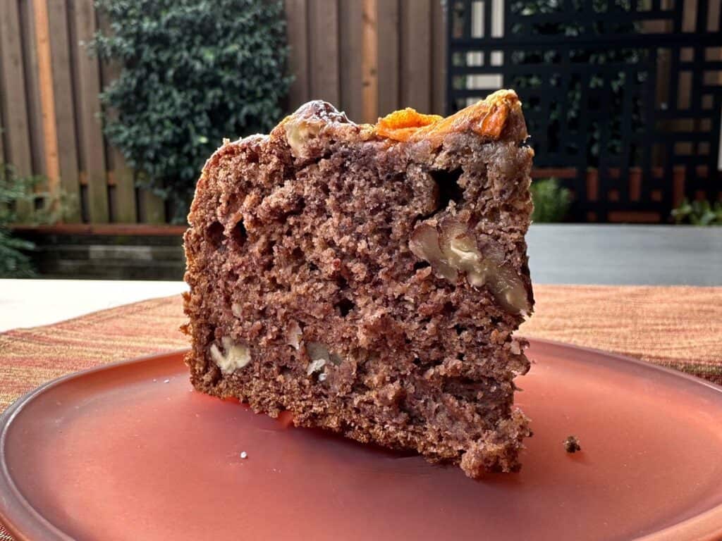 A slice of Wild Persimmon Cake on a small glass plate.