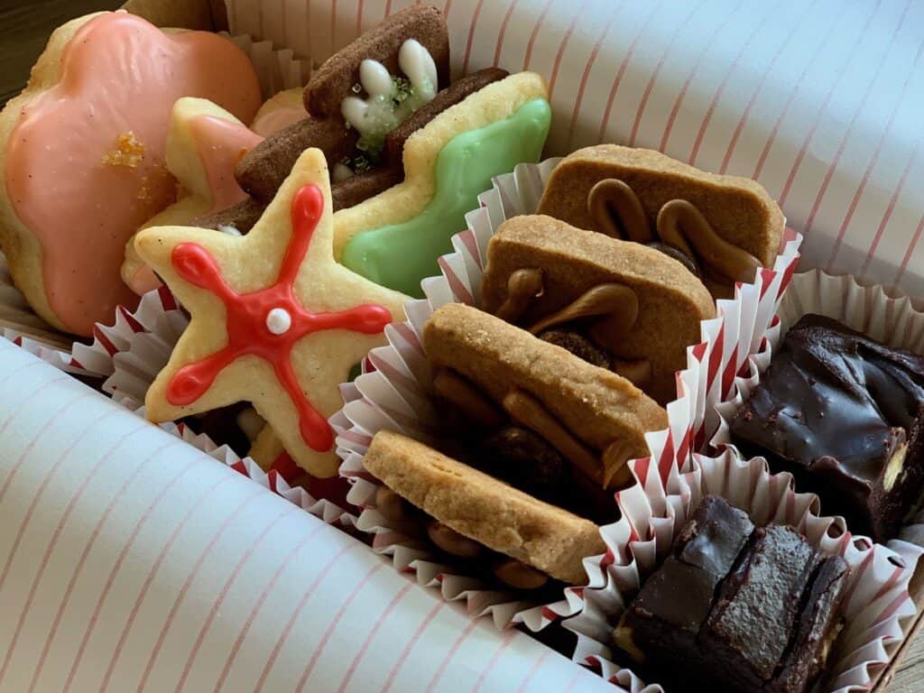 A selection of home baked cookies and candy, including Cinnamon Coffee Crisps, Ginger and Spice Cutout Cookies, Mama Jean's Fudge and Campari Shortbread Cookies, are boxed for gifting.