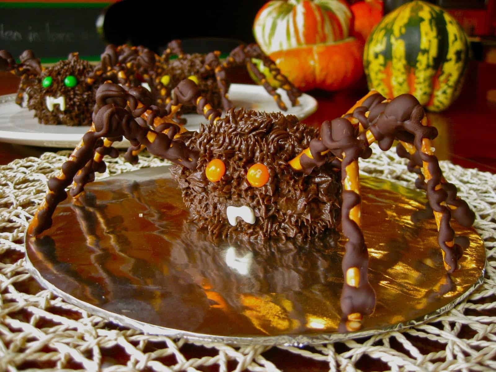 Spider Cupcake with pretzel legs on a web placement with gourds in background