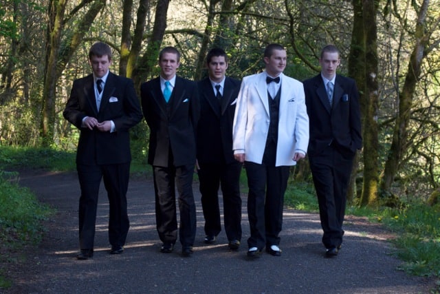 Dressed in tuxes for senior prom, five young men on a path in a wooded setting